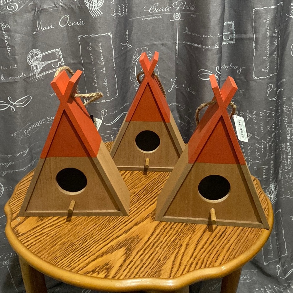 Burnt orange and brown wooden teepee birdhouses.